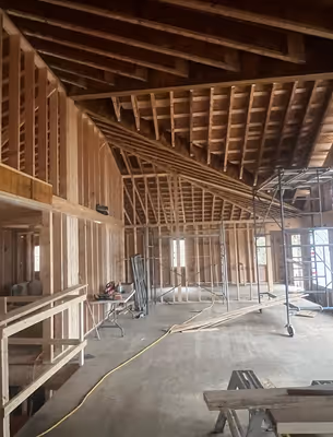 Another interior view of the construction, with exposed wooden framing and what appears to be the beginnings of walls or partitions.